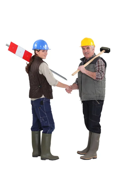 Young female apprentice shaking hands with male instructor — Stock Photo, Image