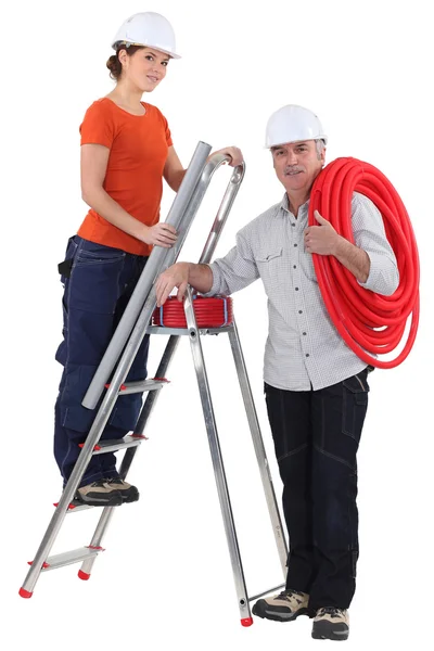 Female plumber on ladder with male tutor — Stock Photo, Image