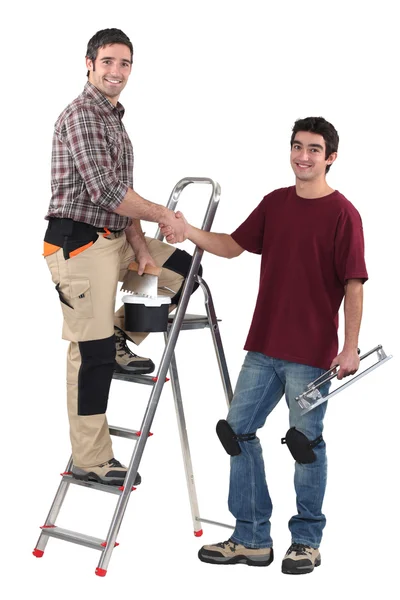 Craftsman and apprentice shaking hands — Stock Photo, Image
