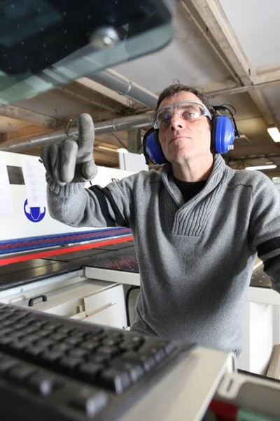 Человек с помощью компьютерной управляемой фабрики машины — стоковое фото