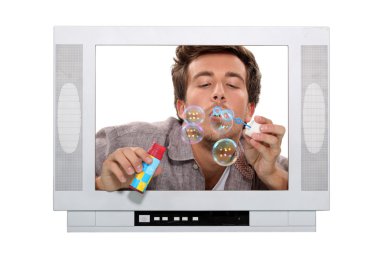 Man blowing bubbles inside television clipart