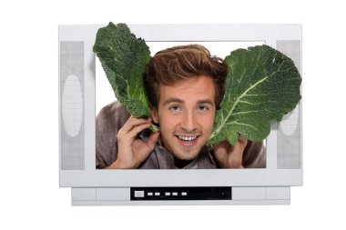 Man with cabbage leaves inside a television clipart