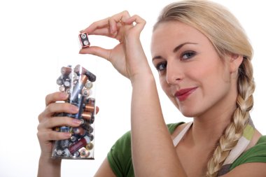 Blond woman recycling used batteries clipart