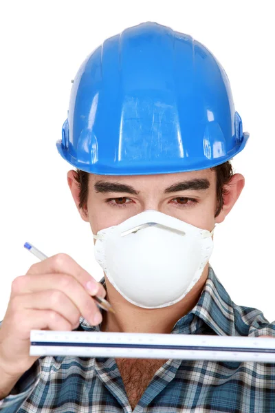 Jovem trabalhador usando máscara protetora — Fotografia de Stock