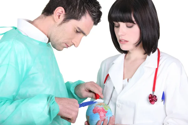 Doctor operating on planet earth — Stock Photo, Image