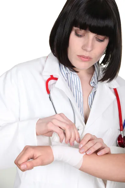 Médecin enveloppant gaze autour du poignet de sa patiente — Photo