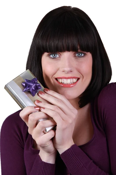 Молодая женщина счастливо держит подарок — стоковое фото