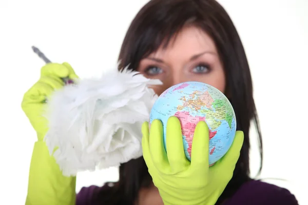 Een werkster schoonmaken van een wereldbol — Stockfoto