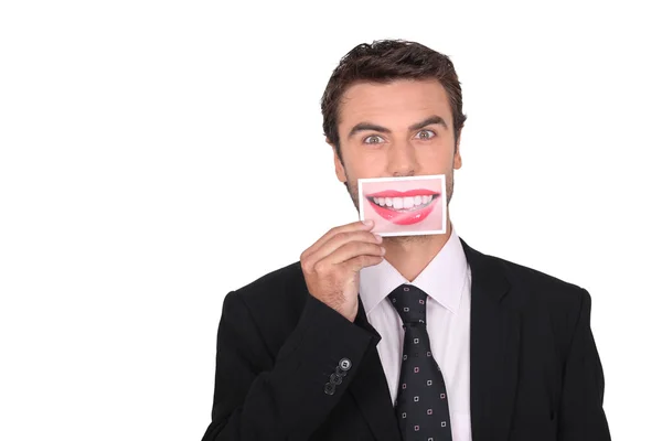 Человек в костюме держит фотографию губ — стоковое фото
