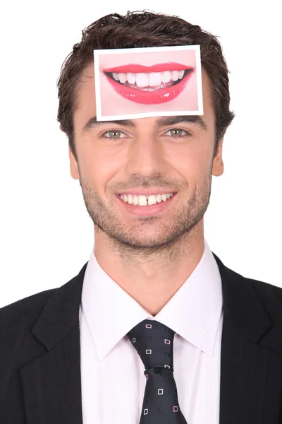 Человек в костюме держит фотографию губ — стоковое фото