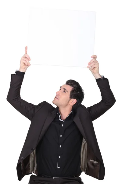 Businessman holding an advertising board — Stock Photo, Image