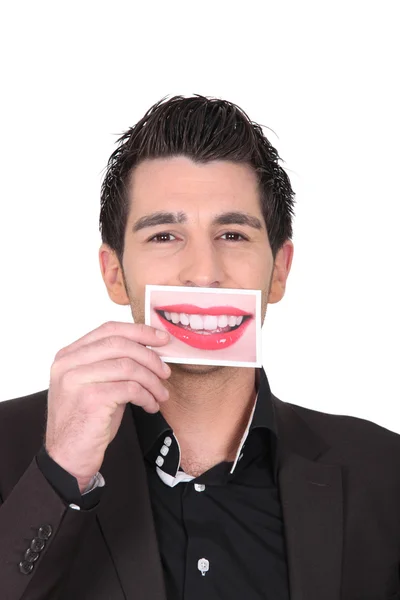Hombre con traje sosteniendo una foto de labios en la boca —  Fotos de Stock