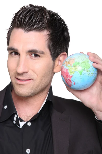 Young man holding a globe — Zdjęcie stockowe