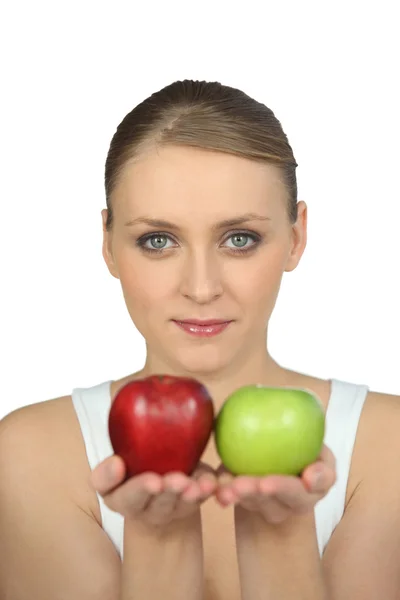 Блондинка с зелеными и красными яблоками — стоковое фото