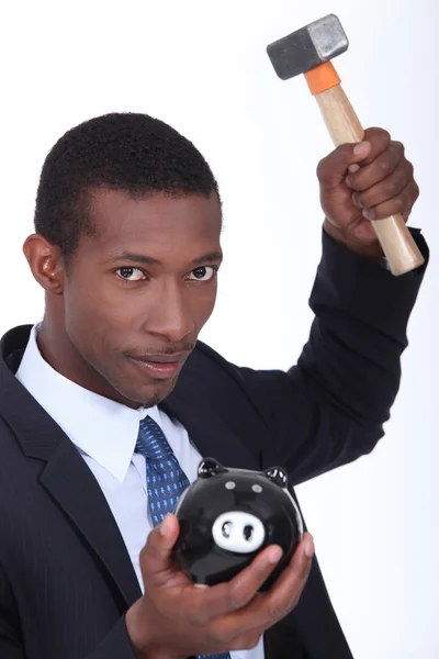 Man about to break open a piggy bank with a hammer — Stock Photo, Image