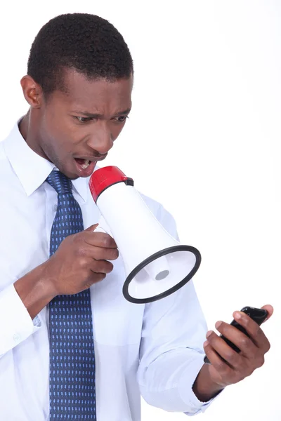 Hombre molesto usando un altavoz para gritar a su teléfono celular —  Fotos de Stock