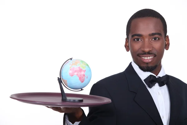 Servitören håller miniatyr globe på bricka — Stockfoto