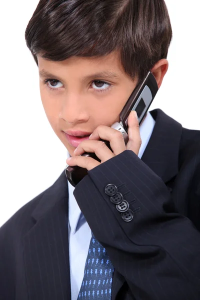 Young boy dressed in a business suit with a mobile phone — Stock Photo, Image