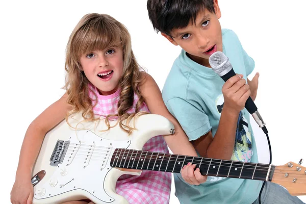Little boy and girl playing musical instruments — Stock Photo, Image