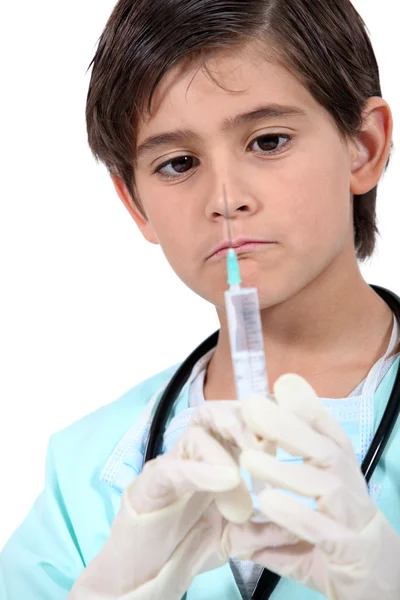 Kleine jongen met spuit verkleed als arts — Stockfoto