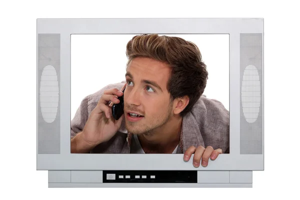 Концептуальний знімок чоловіка на телефоні всередині екрана телевізора — стокове фото