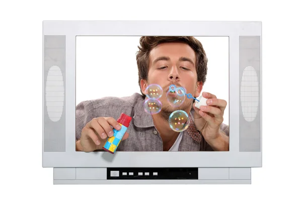 Stock image Man blowing bubbles inside television