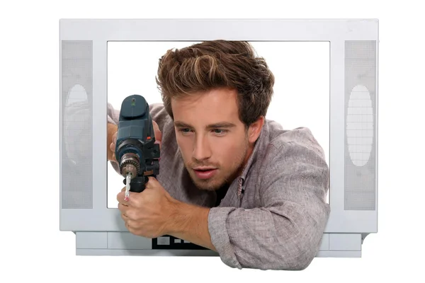 Man drilling in television set — Stock Photo, Image