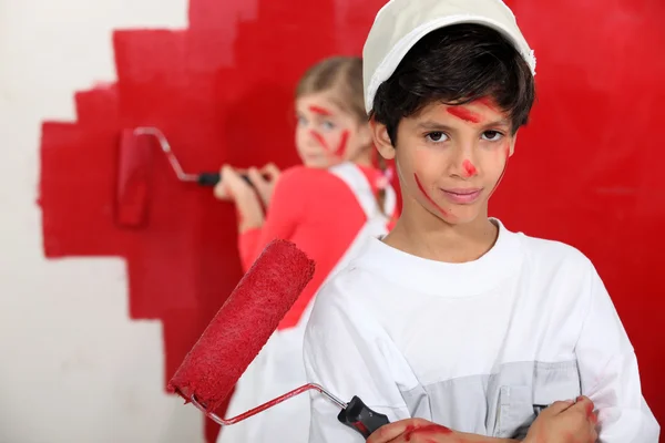 Barn målar väggen i rött — Stockfoto