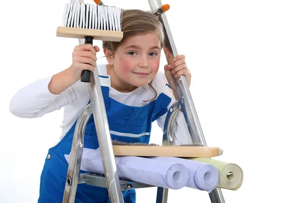 Little girl on a ladder holding a brush and wallpapers — Stock Photo, Image