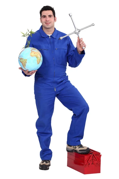 Mechaniker mit Globus und Kreuzradschlüssel — Stockfoto