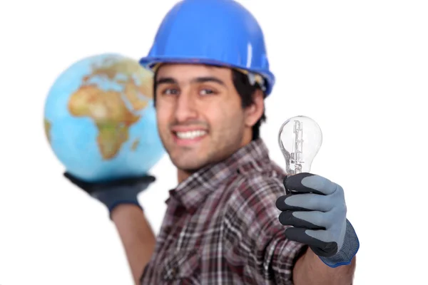 Человек держит глобус и лампочку — стоковое фото