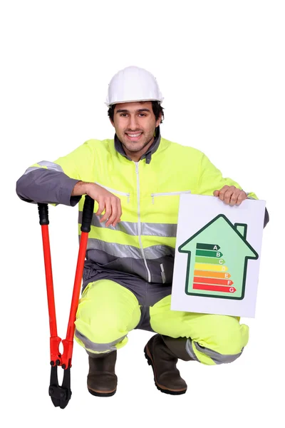 Trabalhador da construção com um símbolo de classificação energética — Fotografia de Stock