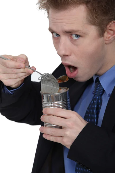 Homem comendo comida enlatada — Fotografia de Stock