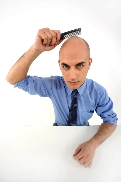 Bald man holding comb — Stock Photo, Image