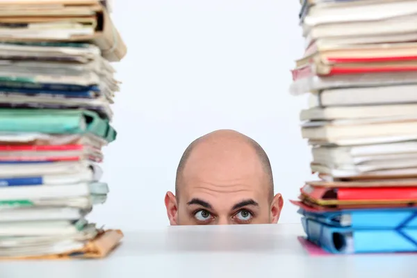 Man peeking through stacks of folders — Stock Photo, Image