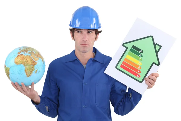 Tradesman con un globo e segno di valutazione energetica — Foto Stock