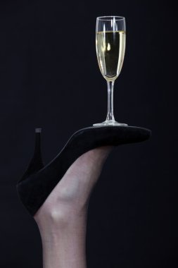 A champagne glass balanced on the sole of a shoe clipart