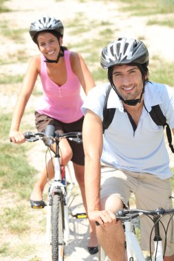 Couple cycling in the countryside clipart