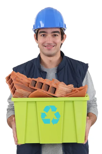 Jovem pedreiro carregando banheira de reciclagem cheia de tijolos vermelhos — Fotografia de Stock