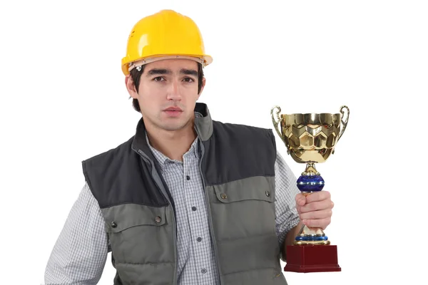 Obrero sosteniendo copa de oro — Foto de Stock