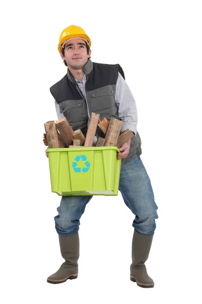 Man die worstelt om te voeren vak van recycleerbaar hout — Stockfoto