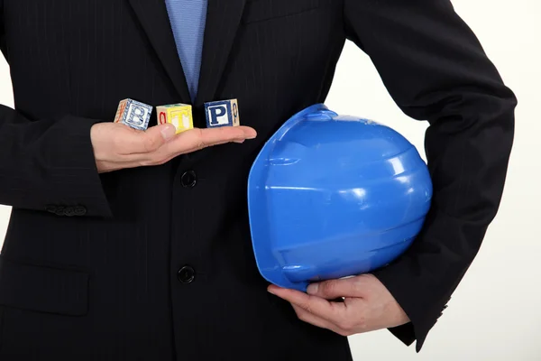 Architect in suit holding hard hat — Stok fotoğraf