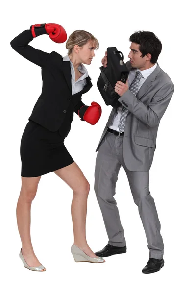 Empresaria amenazando colega masculino con guantes de boxeo —  Fotos de Stock