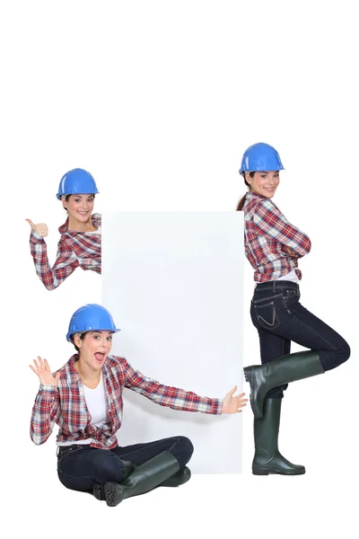 Young craftswoman presenting a blank poster — Stock Photo, Image