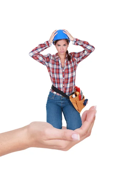 Montage of young female laborer crouching in a hand — Stock Photo, Image