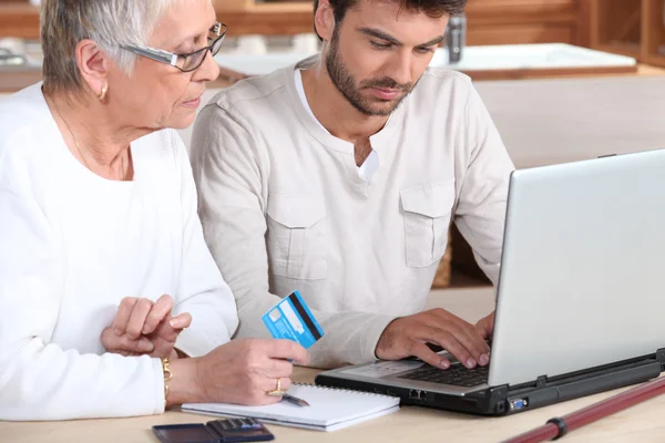 Mann hilft älteren Familienmitgliedern beim Online-Einkaufen — Stockfoto