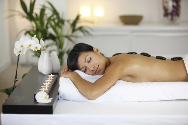 Donna godendo di un massaggio di pietra calda — Foto Stock