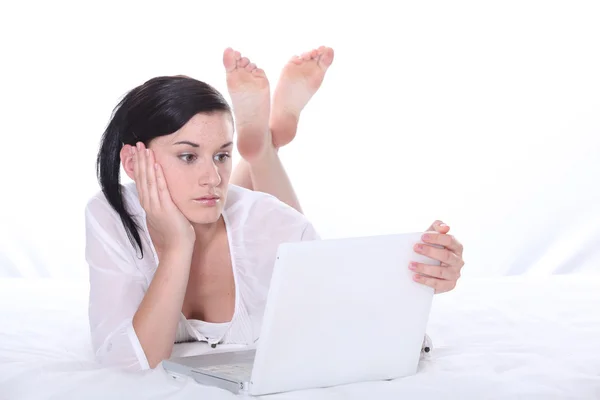 Frau lag mit Laptop im Bett — Stockfoto