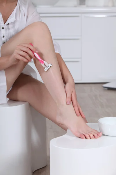 Woman shaving her legs — Stock Photo, Image