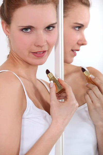 Γυναίκα εφαρμογή χείλη-ραβδί στον καθρέφτη — Φωτογραφία Αρχείου